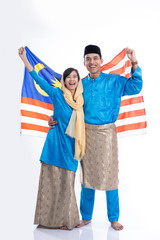 muslim couple wearing melayu traditional clothes holding malaysia flag