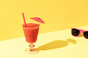 Strawberry smoothie glass and sunglasses. Sunny summer concept