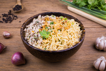 Instant noodles with pork in wooden bowl