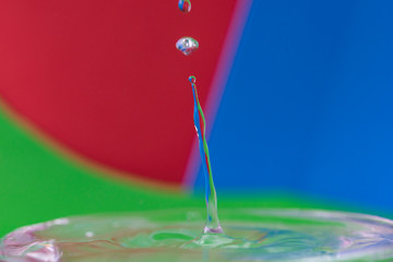 macro photography of water drops with blue-green and red background