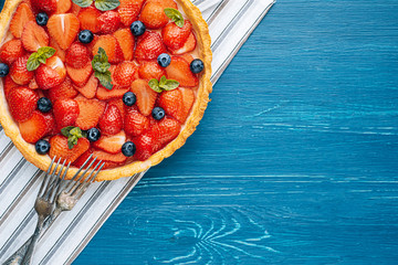 strawberry custard pie with lime zest added to which are sliced strawberries with blueberries and...