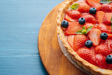 strawberry custard pie with lime zest added to which are sliced strawberries with blueberries and...