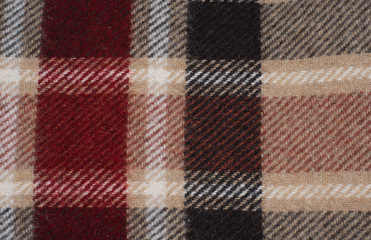 Fototapeta na wymiar woolen blanket with a pattern of red and beige Scottish cage 