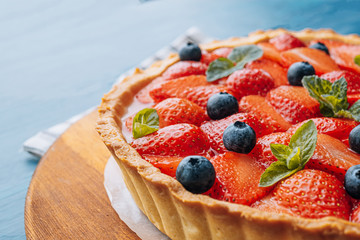 strawberry custard pie with lime zest added to which are sliced strawberries with blueberries and...