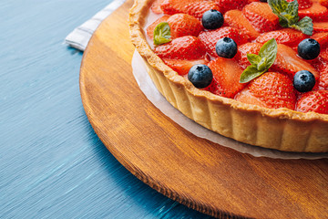 strawberry custard pie with lime zest added to which are sliced strawberries with blueberries and...