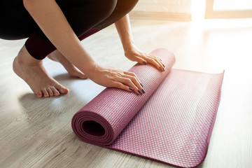 time for yoga. girl unfolds yoga mat at home, sportswoman is ready to do yoga, close-up © Богдан Маліцький
