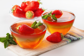 Fruit jelly with strawberries on a white table