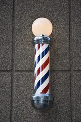 A barber shop pole on side of building 