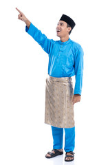 Naklejka premium happy young malaysia male looking up pointing to copyspace