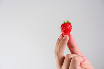 Obraz premium Fresh organic strawberries in mans hand isolated on white background.