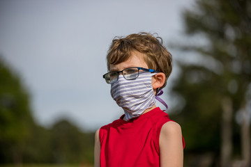 Naklejka premium Young boy demonstrating how to properly wear a mask