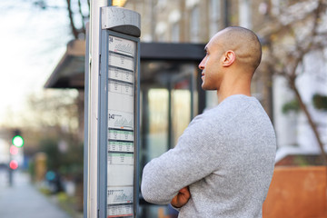 young man reading the bus timetable