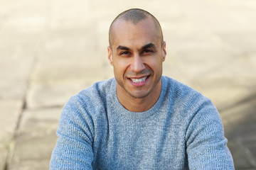 portrait of a casual man sitting in the street