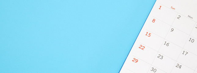 calendar page close up on blue background business planning appointment meeting concept