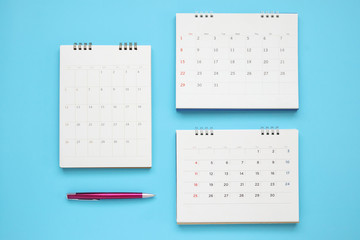 calendar page with pen close up on blue background business planning appointment meeting concept