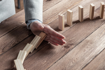 Business woman hand stop domino effect