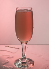 Glasses with red wine on a background reflection, pink background