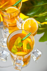 Two glasses of cold refreshment tea with ice and lemon fruit.