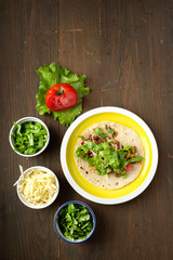 Yellow plate with mexican speciality beef tacos on a wooden table