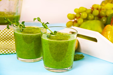 Fresh blended green smoothie in glasses with fruit and vegetables on the background. Health and...