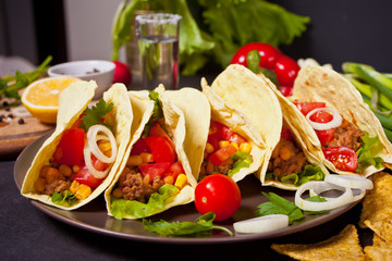 Mexican tacos with chicken meat, beans, tomatoes and corn