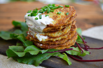 potato patties stacked with fresh herbs.