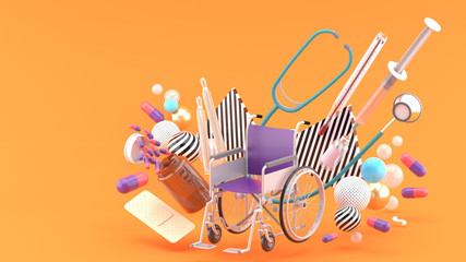 Wheelchair surrounded by, syringe, thermometer, capsule, stethoscope and band aid amidst colorful balls on an orange background.-3d rendering..