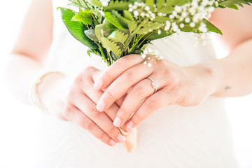 Obraz na płótnie Canvas Bride with White Gold Wedding Ring Holding Fresh Gypsophila Bouquet