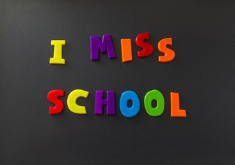 The words I miss school written on a refrigerator door with magnet letters. Message during self isolation from COVID-19 corona virus flu