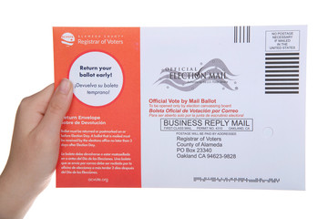 Alameda, CA - May 11, 2020: Young caucasian hand holding mail in ballot. Governor Gavin Newsom just announced California will be a vote by mail only state for the 2020 Presidential election.