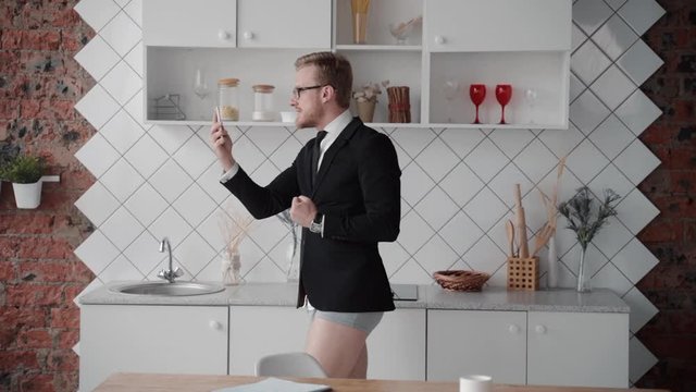 confident business man discuss plans, motivates employees with gestures. online internet conference from isolation quarantine. telework inside. half dressed male in undies underwear and jacket