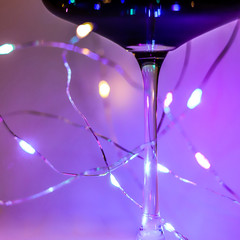 element of a festive glass with red wine and garland lights