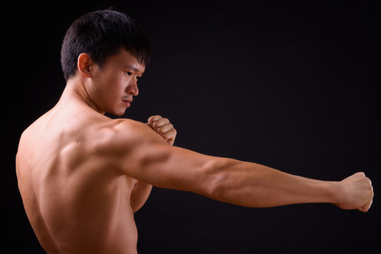 Portrait of young muscular Asian man shirtless ready to fight