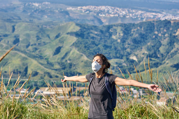 Woman with a protective mask sunbathes in the field.