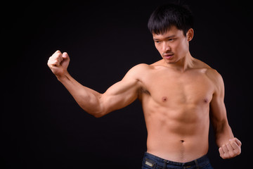 Fototapeta na wymiar Portrait of young muscular Asian man shirtless ready to fight