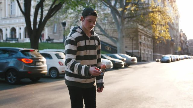 Young teenage boy playing kendama outside in city during beautiful sunset