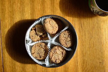 Tin can with cookies on a wooden table. View from above