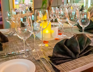 Romantic dinner table setup decoration with candle light in a restaurant. Selective focus.
