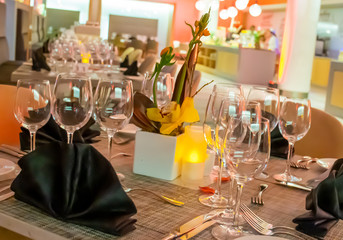 Romantic dinner table setup decoration with candle light in a restaurant. Selective focus.