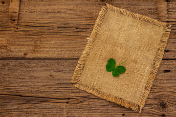 Four-leaf clover, fresh plant on sackcloth. Good luck symbol, St.Patrick's Day concept