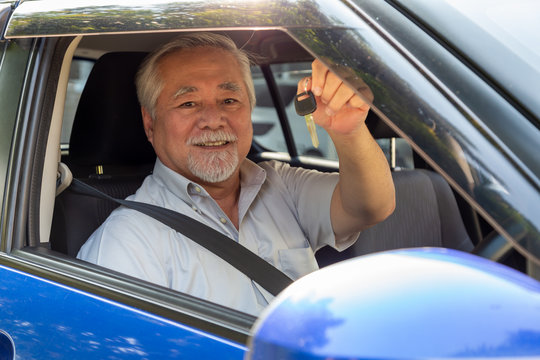 Asian Senior Man Driver Smiling And Showing New Car Keys And Sitting Inside The Car