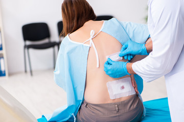 Injured young woman visiting young male doctor