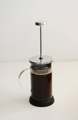 Brewing coffee in french press. Plunger not lowered. White background