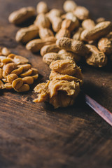 Peanuts in many ways: peeled, shelled and in peanut butter on a rustic wooden table