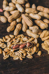 Peanuts in many ways: peeled, shelled and in peanut butter on a rustic wooden table