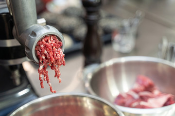 Minced raw meat coming out of a grinder