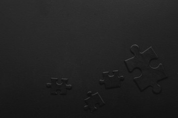four black puzzles on a dark background