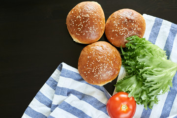 blank for homemade burgers, sesame rolls, tomato and lettuce