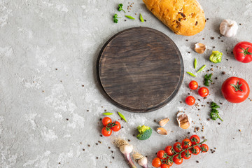 cuting board and spices with copy space with vegetables tomatoes paper and bread spices gray texture wooden board