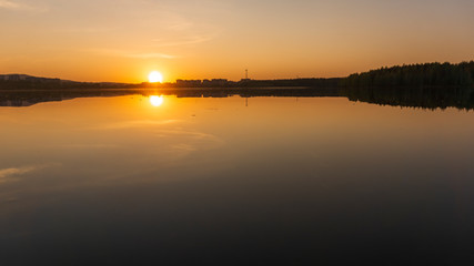 Obraz premium sunset over the lake near the city photo